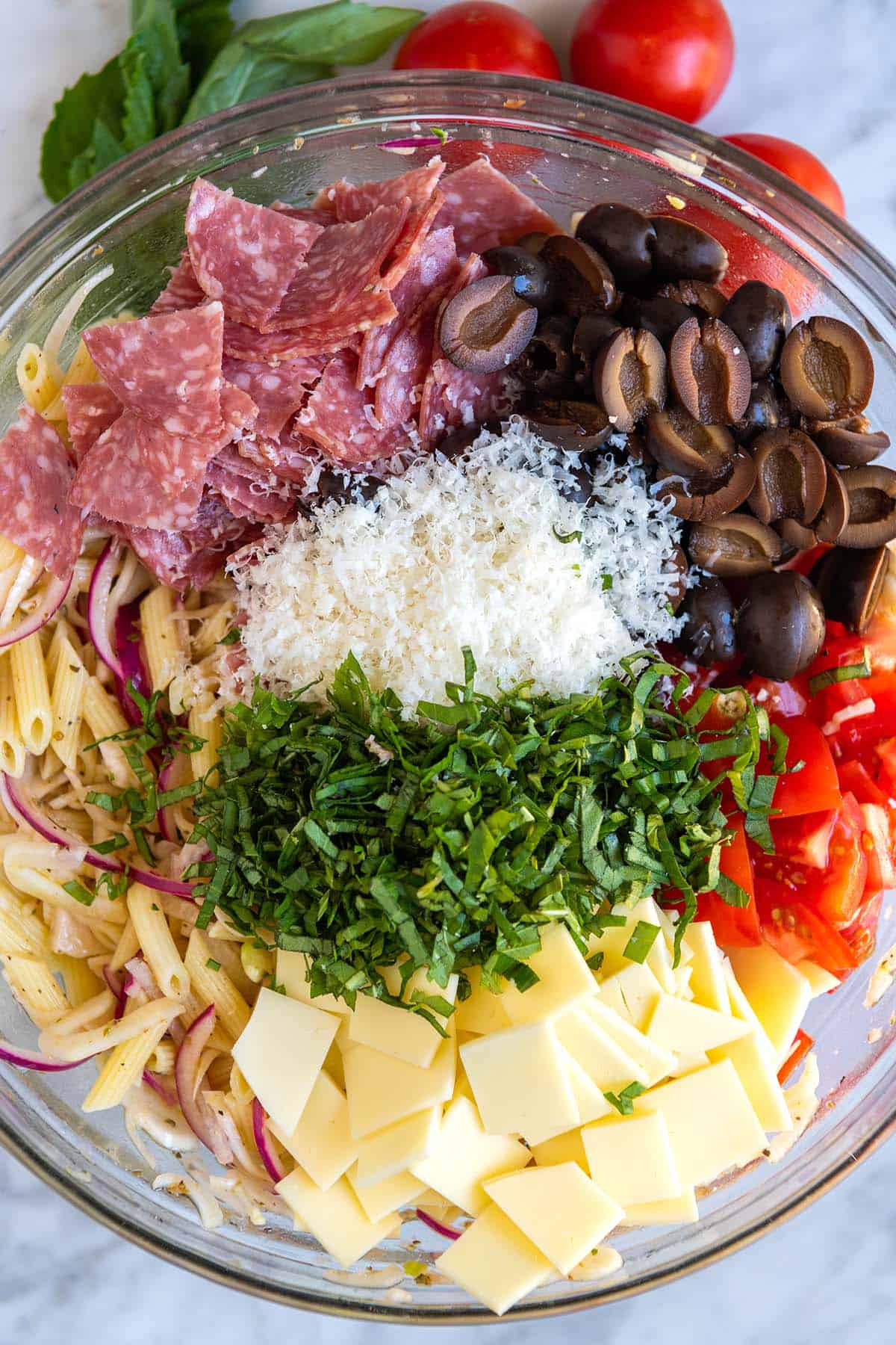 Italian Pasta Salad Ingredients -- Pasta, cheese, basil, tomatoes, onions, olives