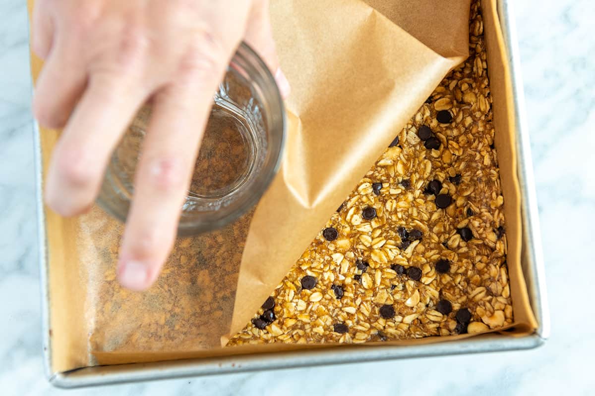 Pressa ut granolablandningen i en kastrull för att göra granolastänger