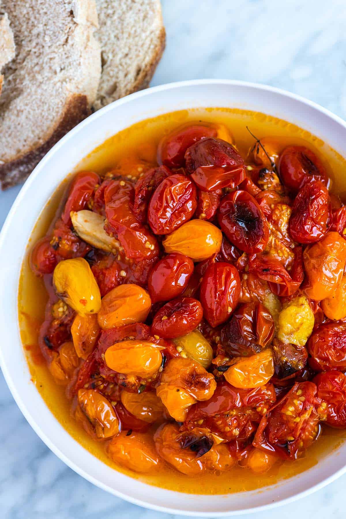 A bowl of roasted tomatoes with garlic.