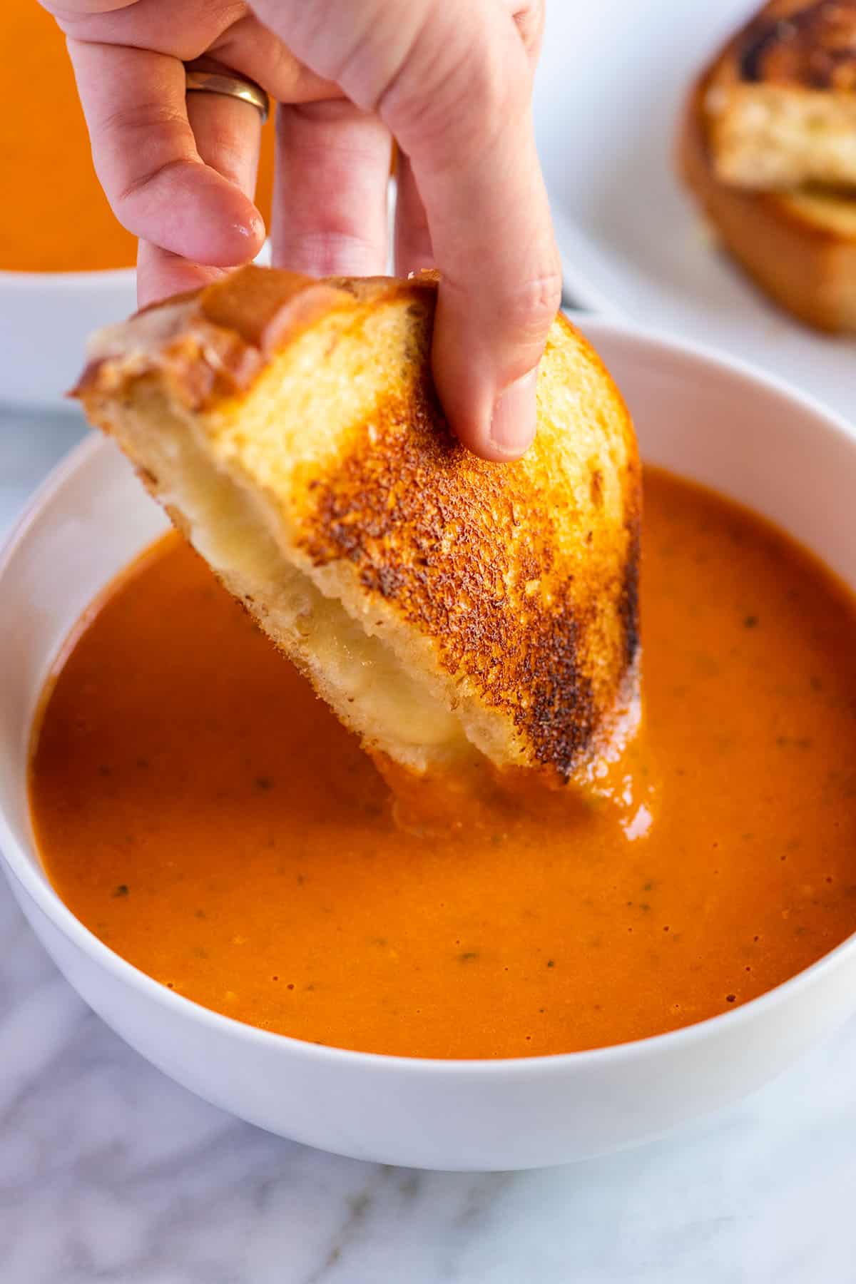 Una ciotola di zuppa di pomodoro arrosto con formaggio grigliato