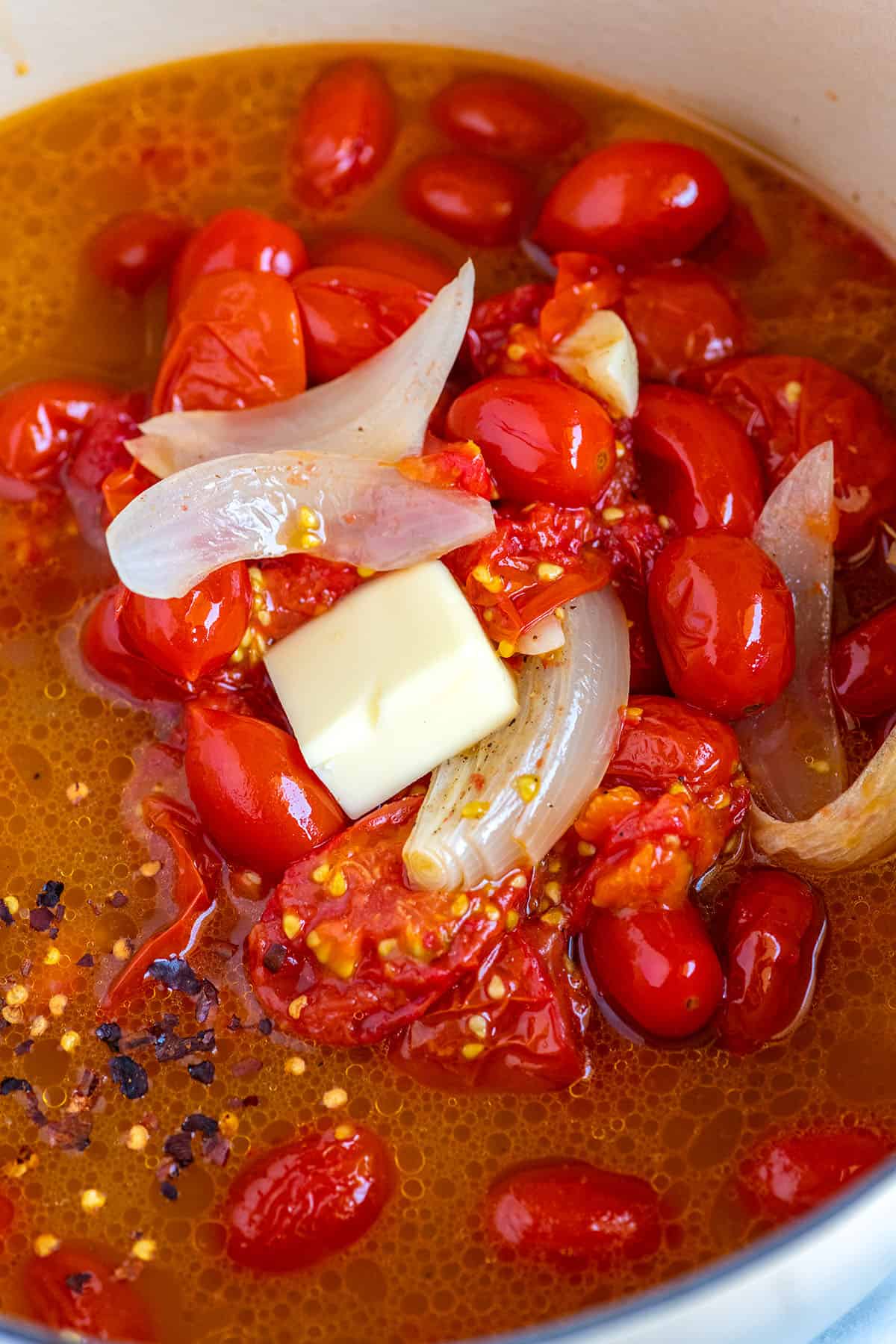 Göra rostad tomatsoppa.  Rostade tomater med buljong i en soppgryta.