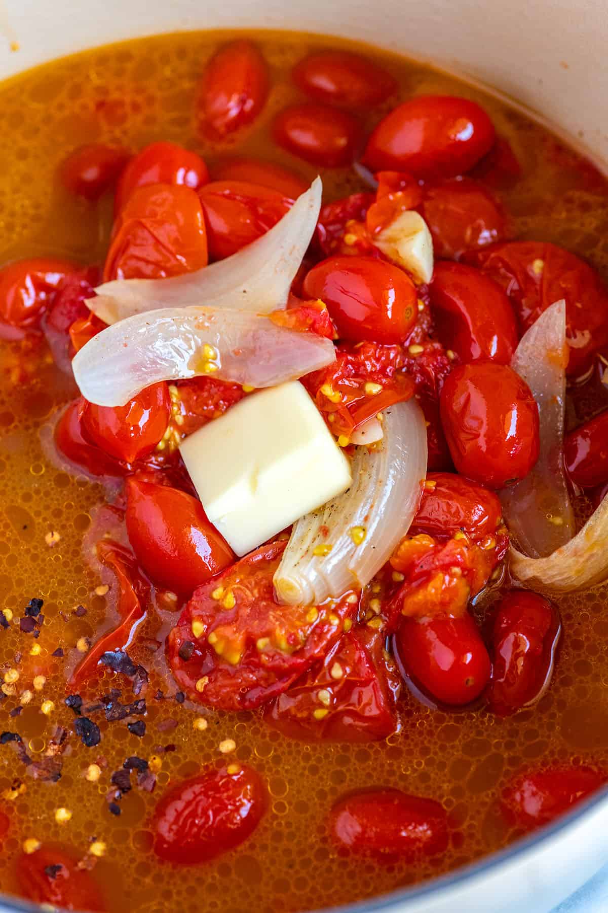 Making roasted tomato soup. Roasted tomatoes with broth in a soup pot.