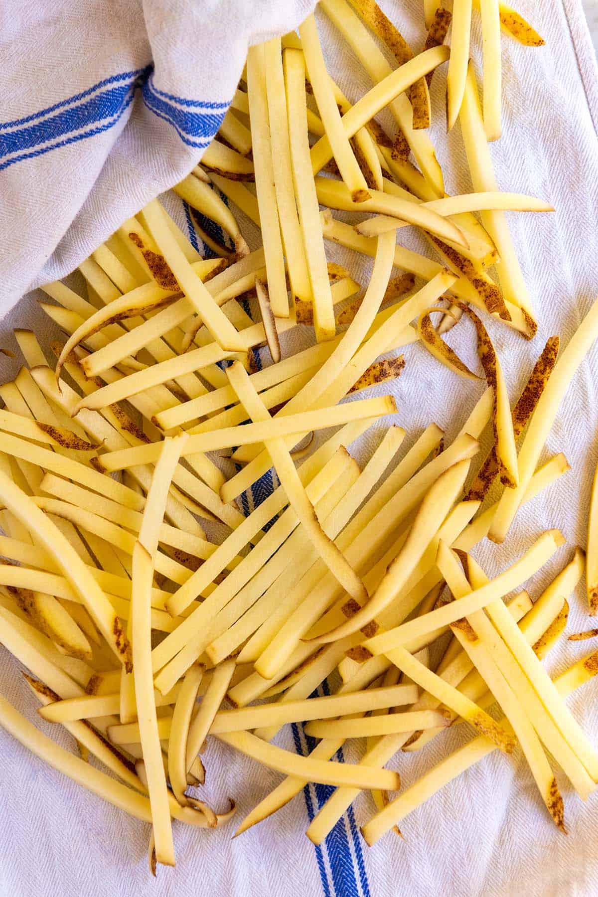 torka blötlagda pommes frites innan du slänger med kryddor och bakar