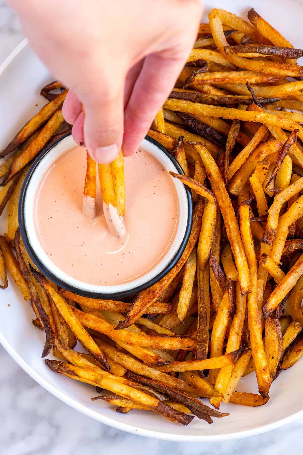 Dipping french fries into fry sauce