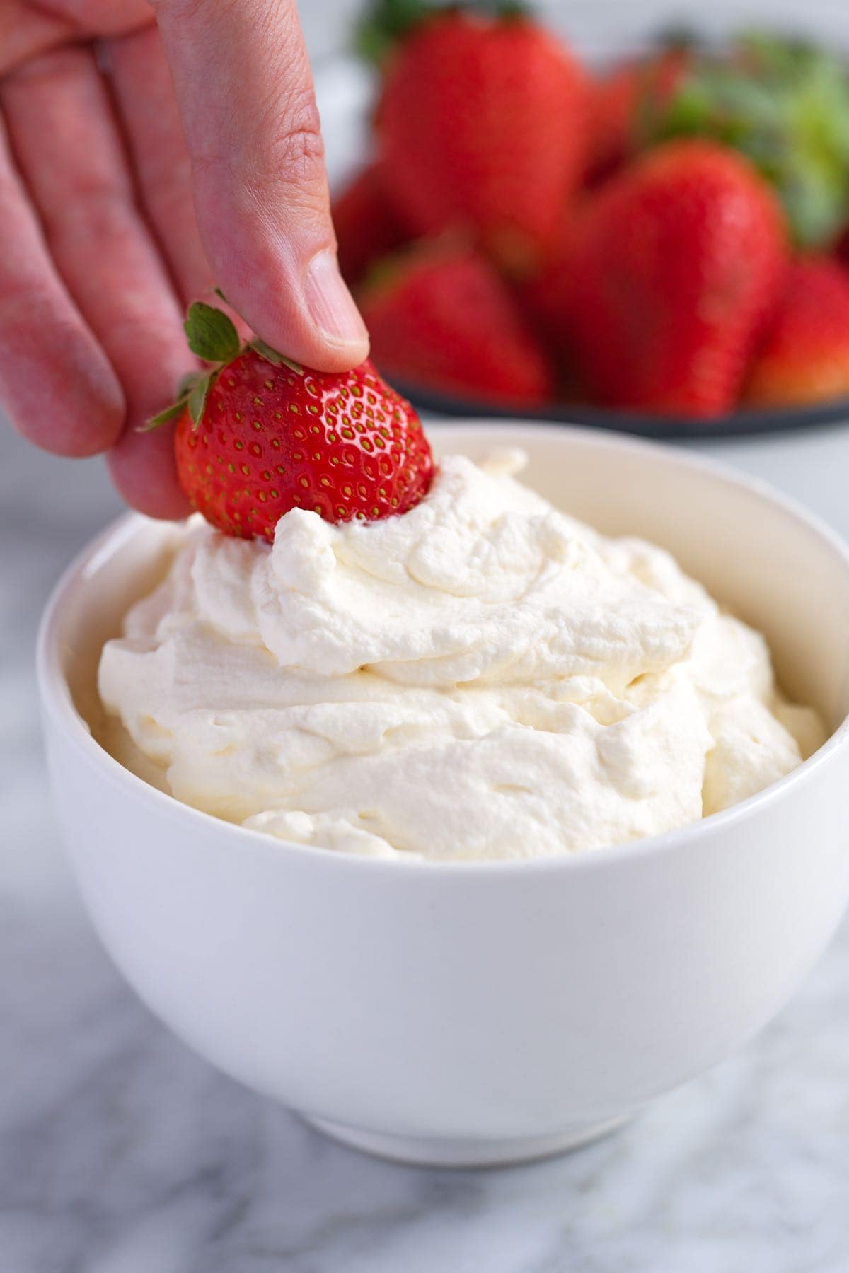 Dipping a strawberry into homemade whipped cream