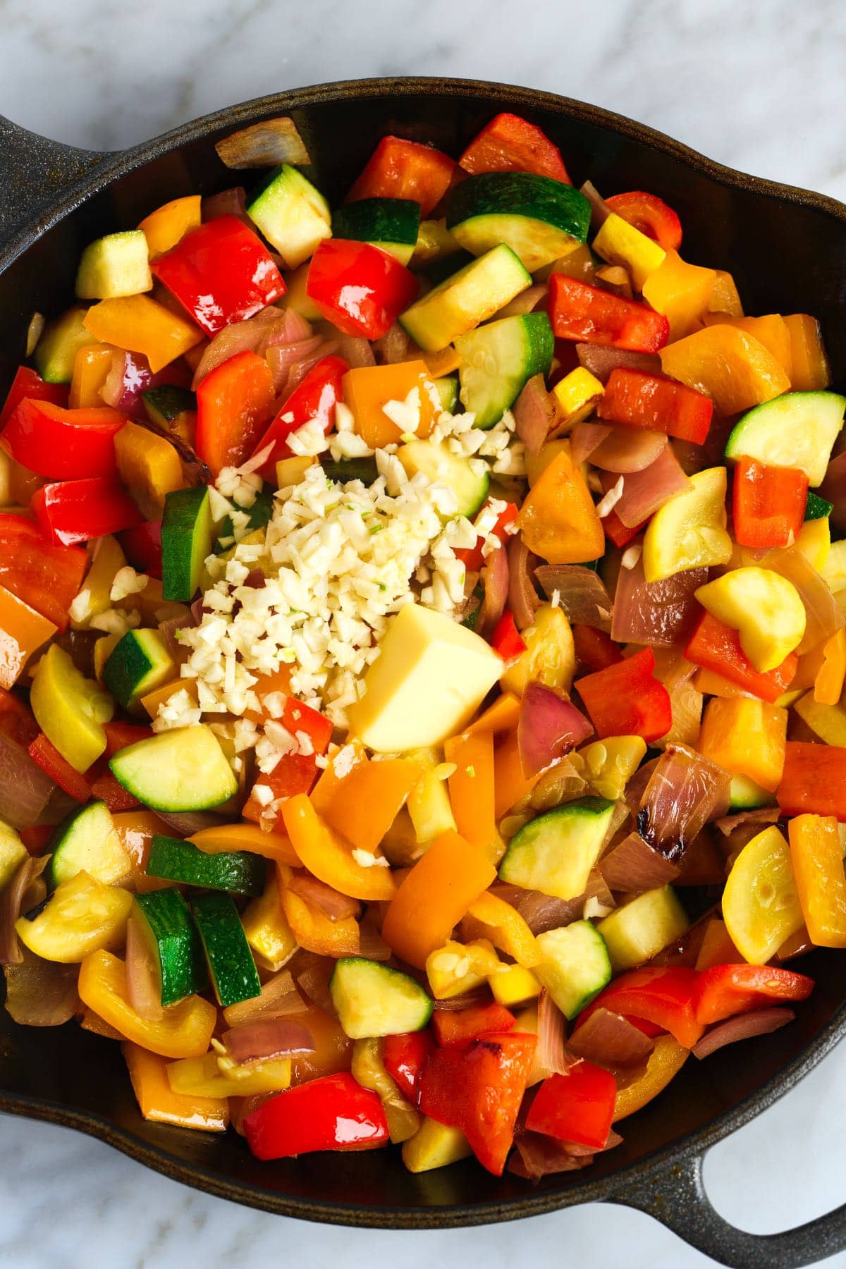 Adding garlic and butter to the vegetables