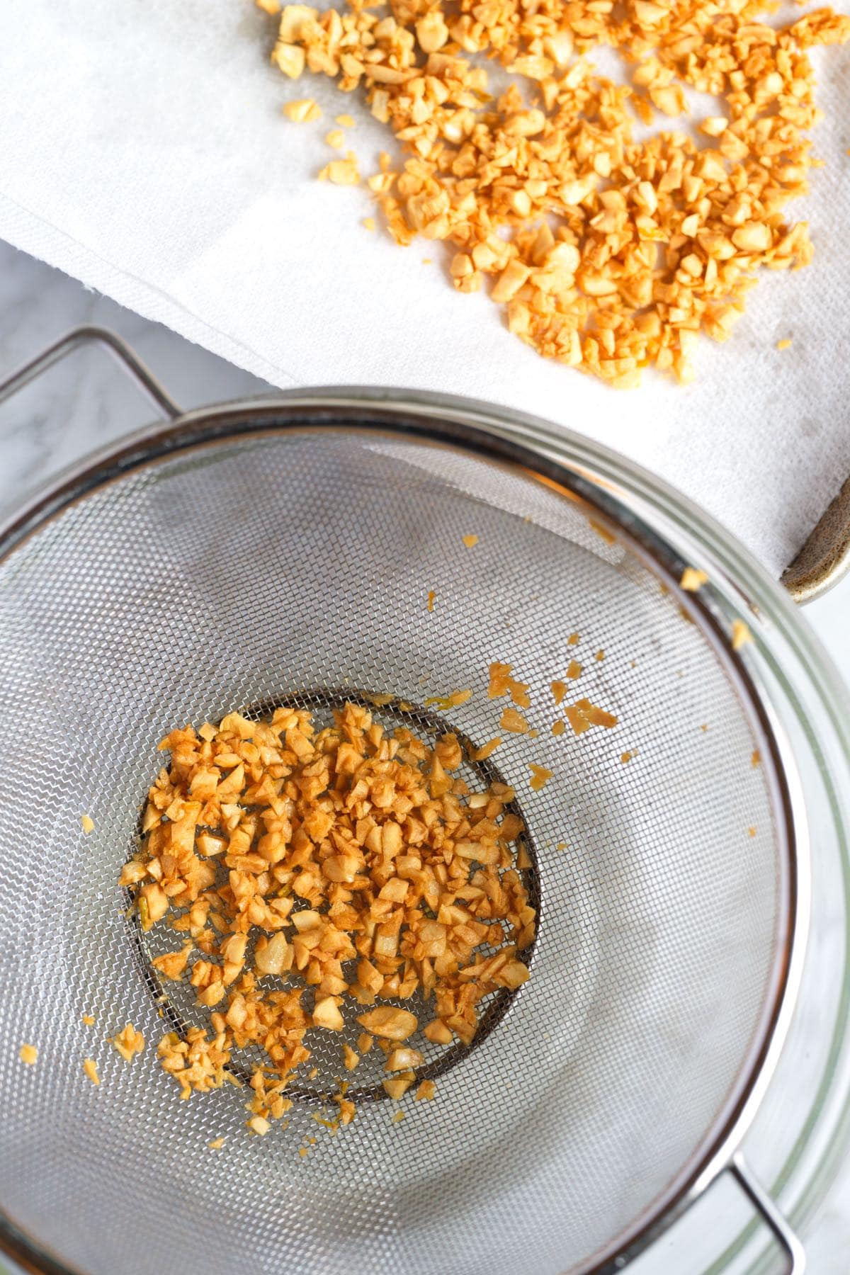 Draining fried garlic on paper towels.