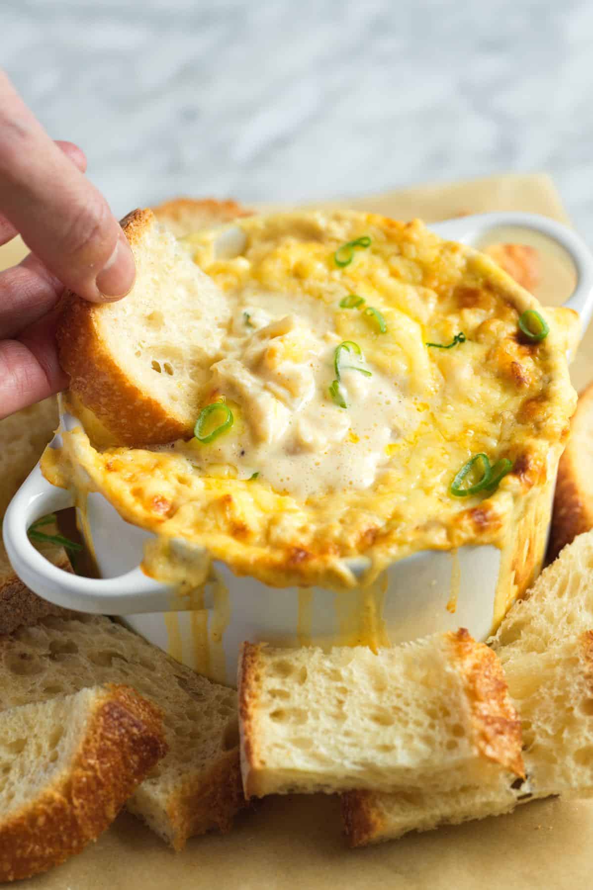 Dipping bread into hot crab dip