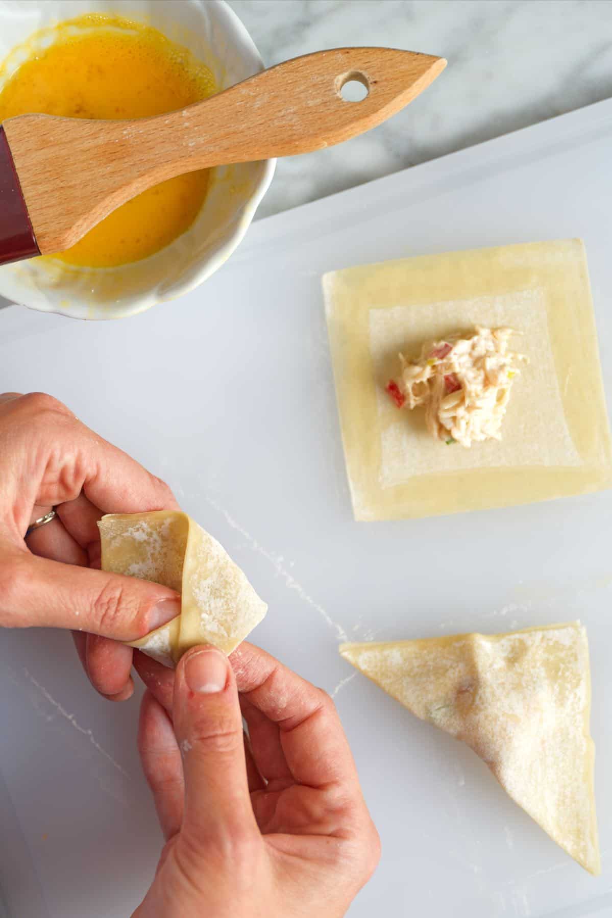 Folding wontons for crab rangoon