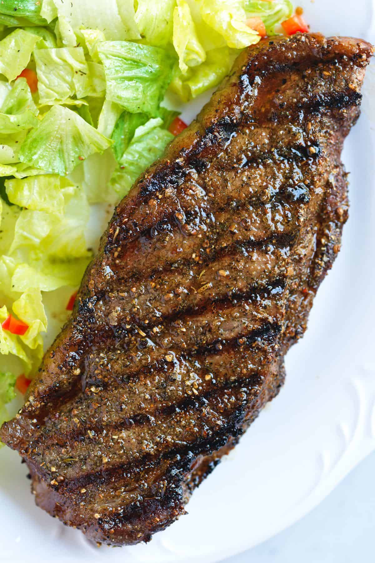 Steak grillé à côté d'une salade