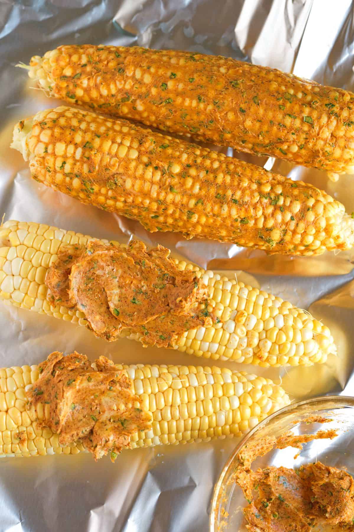 Cajun butter spread onto corn on the cob