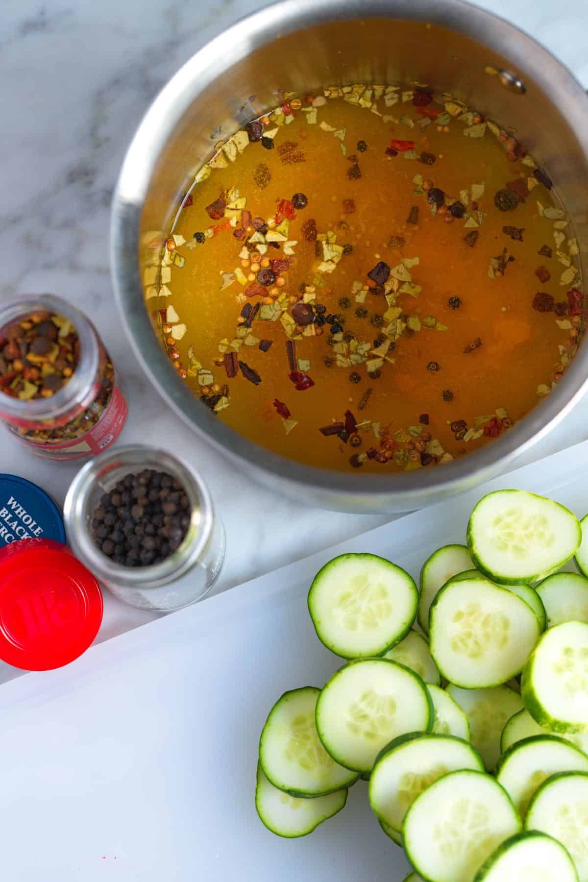 Making bread and butter pickles -- brine, spices and sliced cucumbers