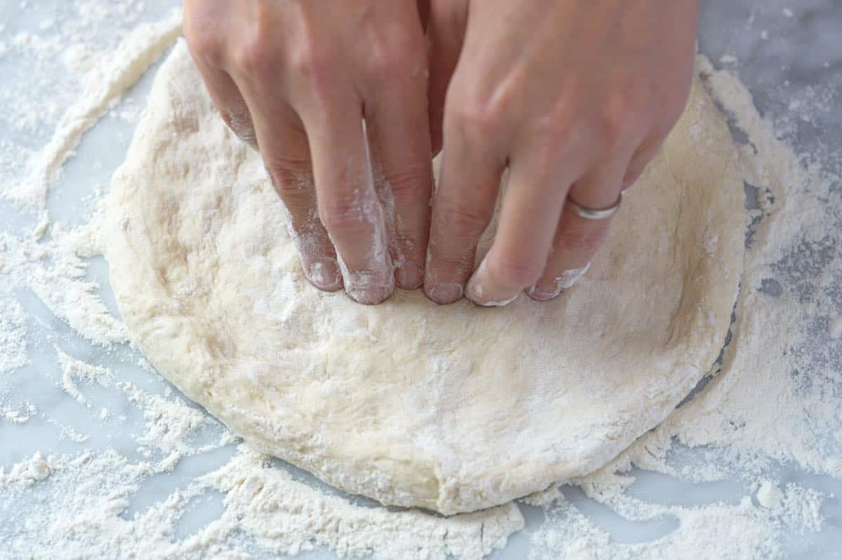 Showing how to stretch pizza dough.