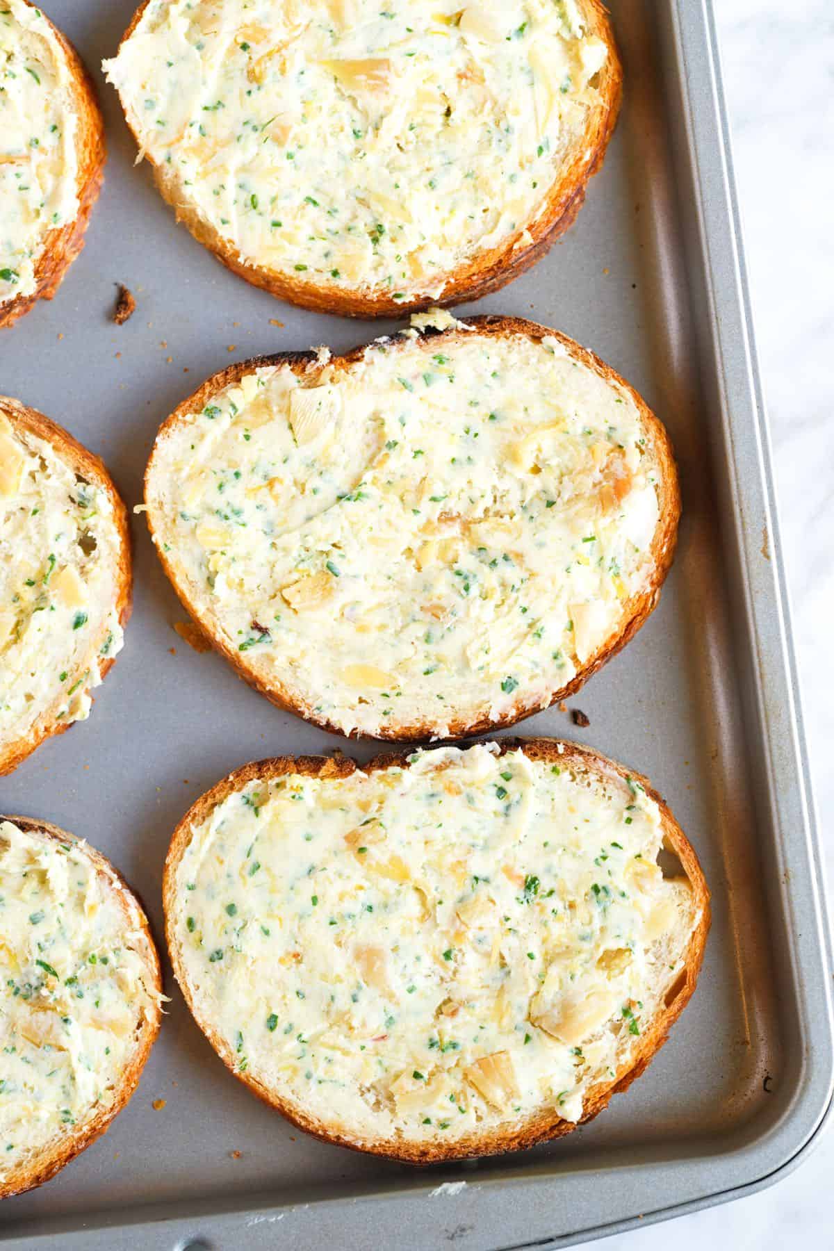 Bread spread with roasted garlic butter ready for the oven.