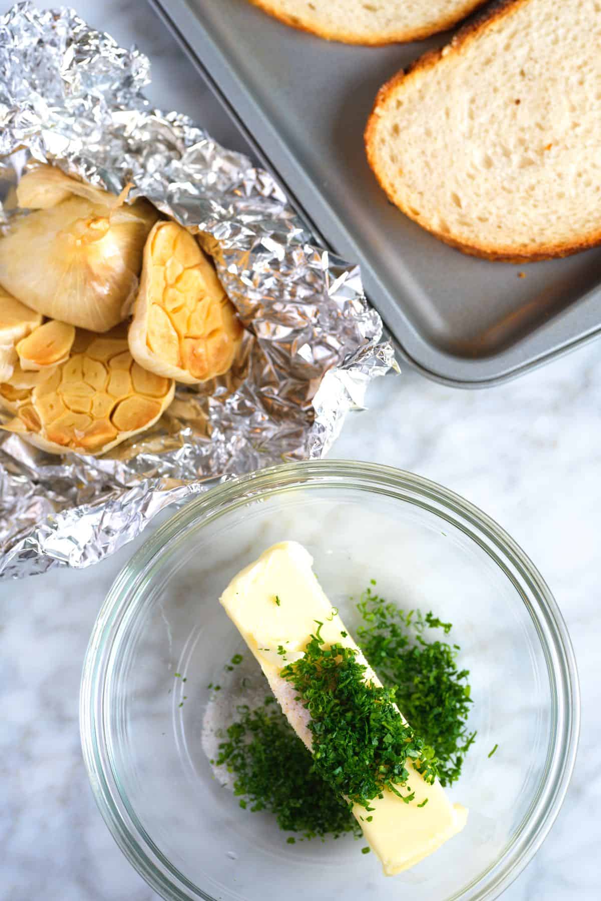 Roasted garlic, bread slices, and butter