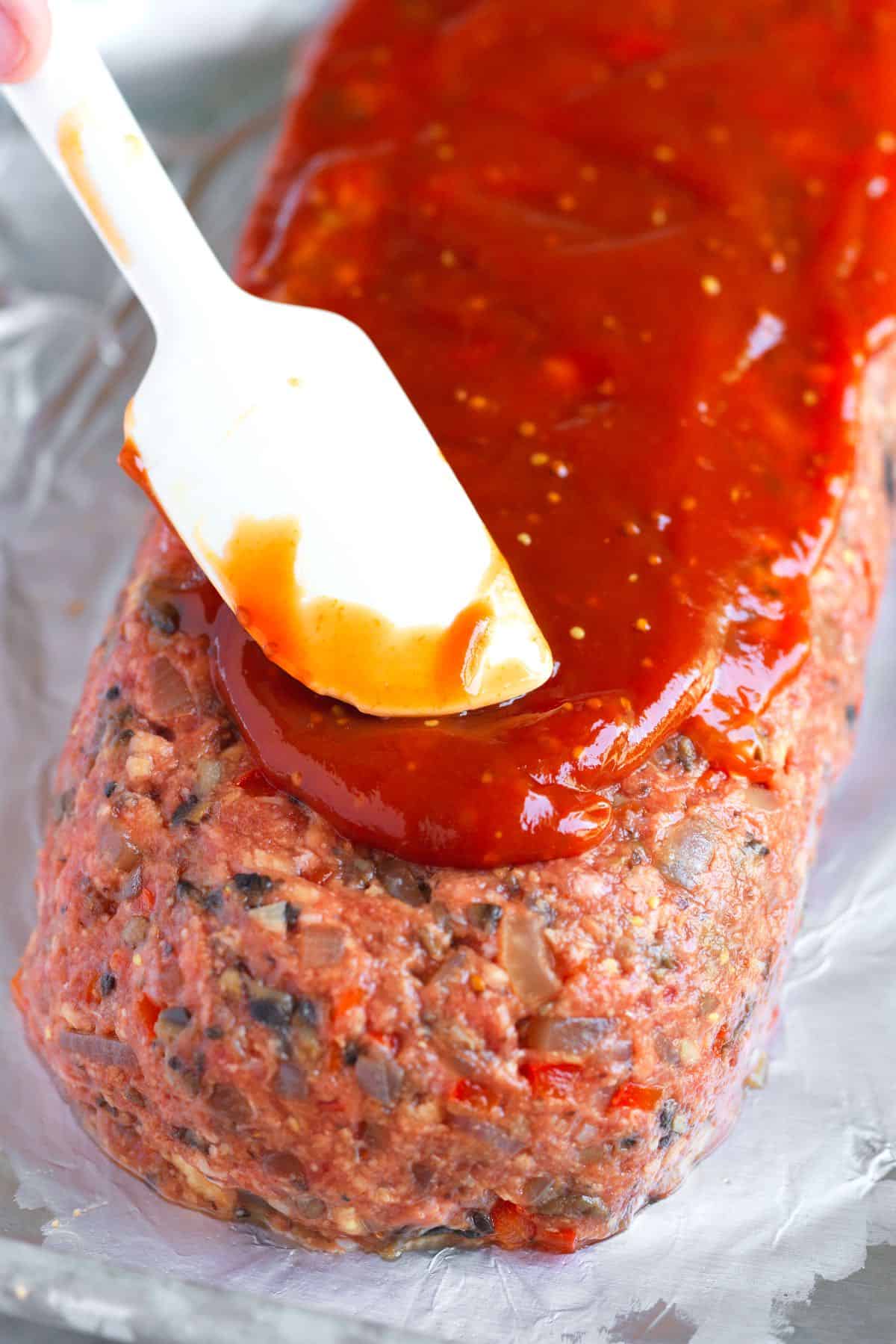 Adding our meatloaf glaze to the top of meatloaf