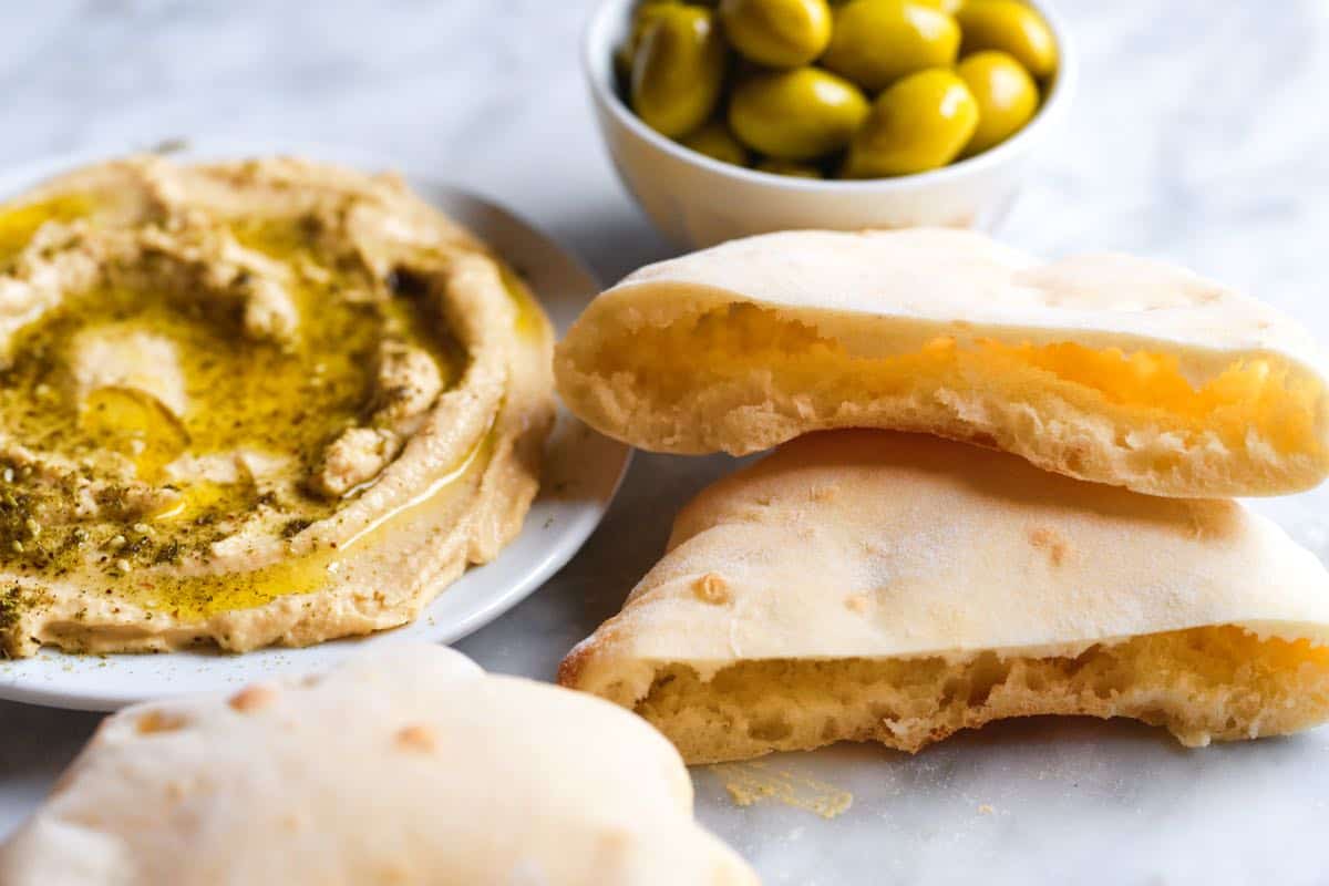 Hummus served with pita bread and olives