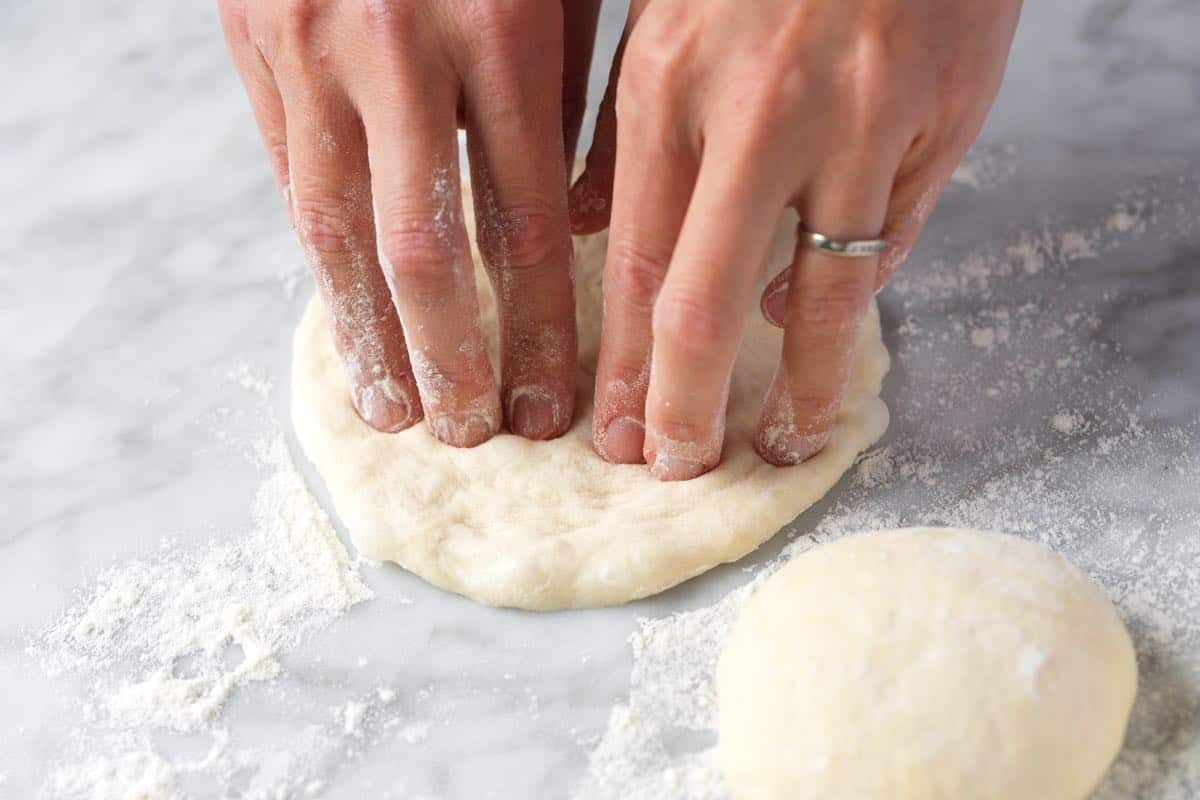 Flattening our dough balls for pita
