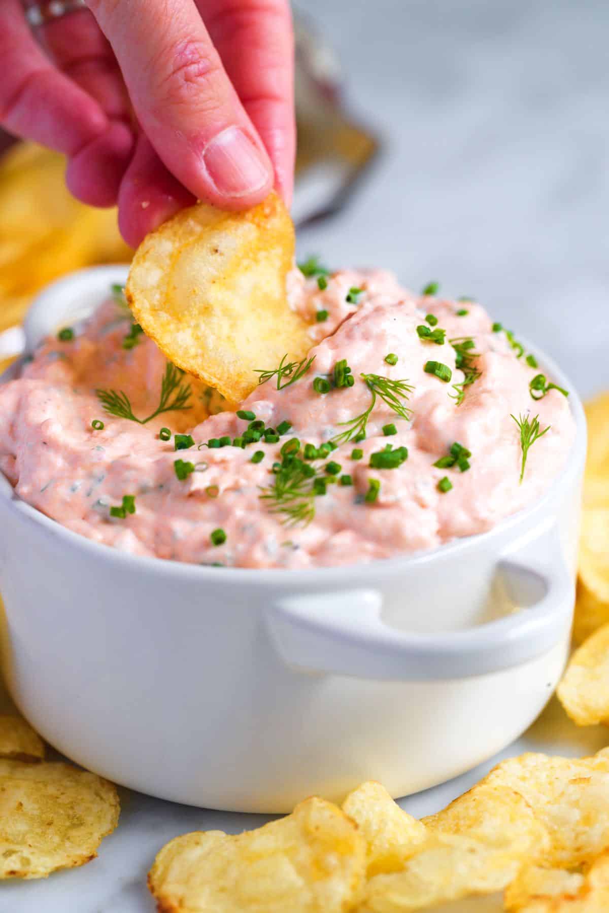 dipping a chip into salmon dip