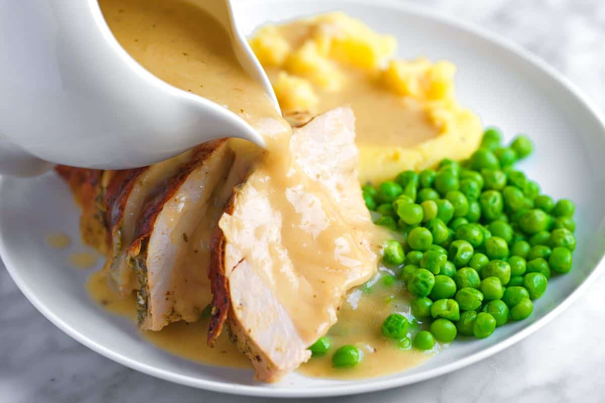 Homemade Turkey Gravy being poured over roasted turkey