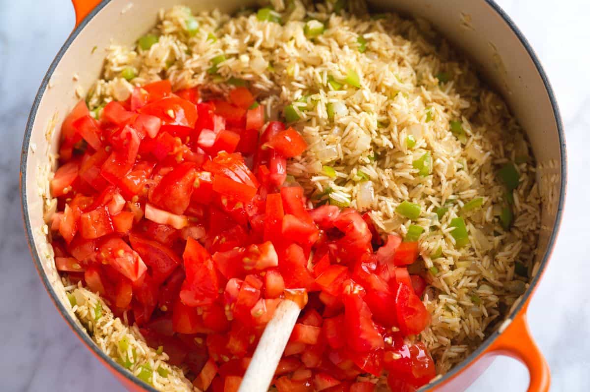Adding fresh tomatoes for the best homemade Mexican rice