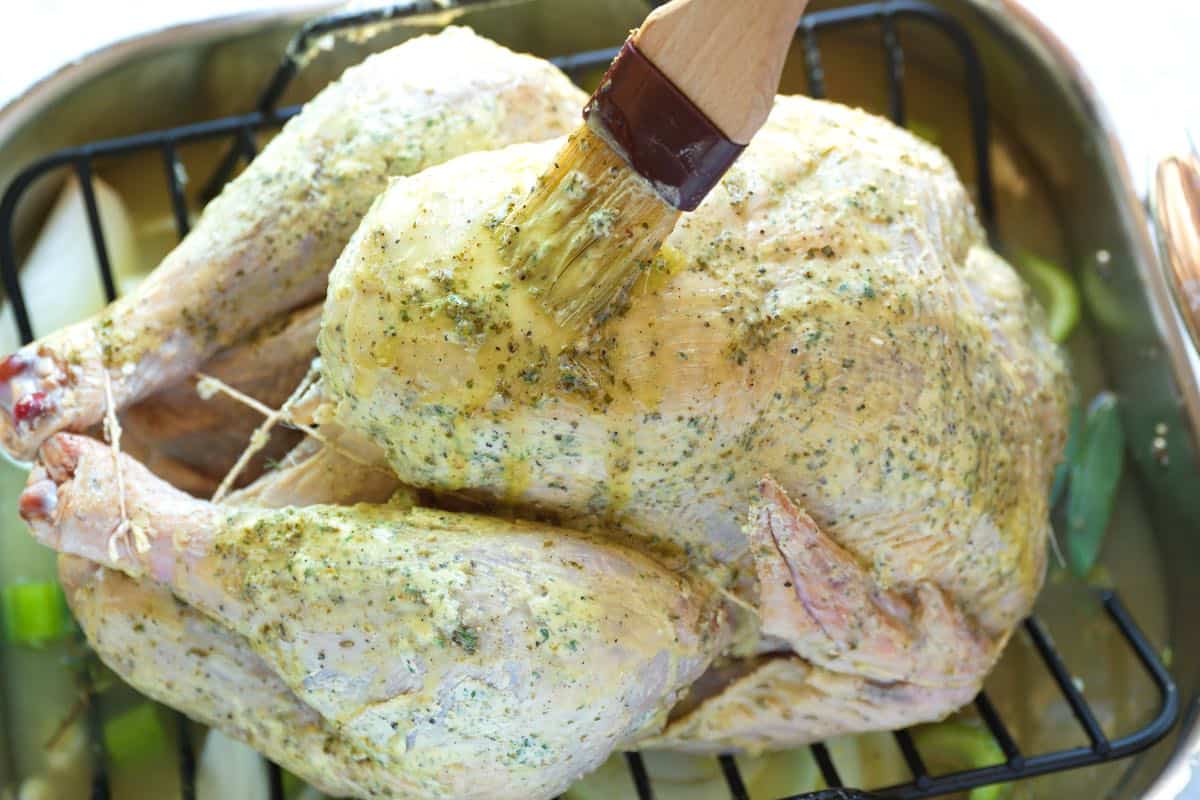 Adding herb butter to turkey before roasting