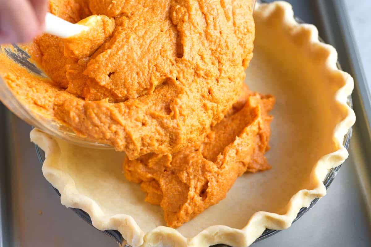 Adding sweet potato pie filling to the pie crust