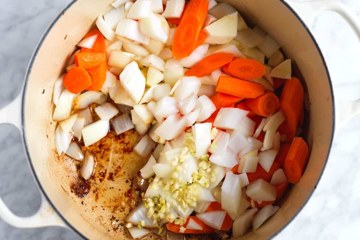 Building flavor in beef stew - vegetables simmering in rich beef drippings.