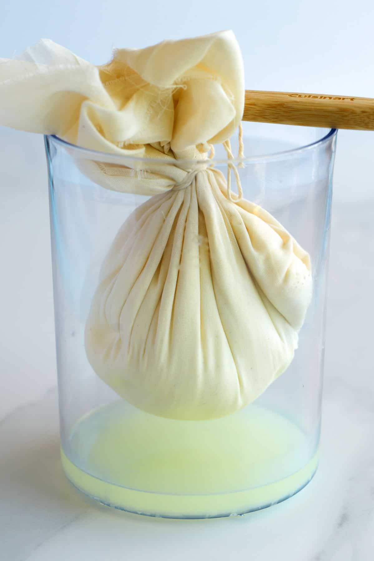 How to make Labneh - Strained salted yogurt in cheesecloth with whey.