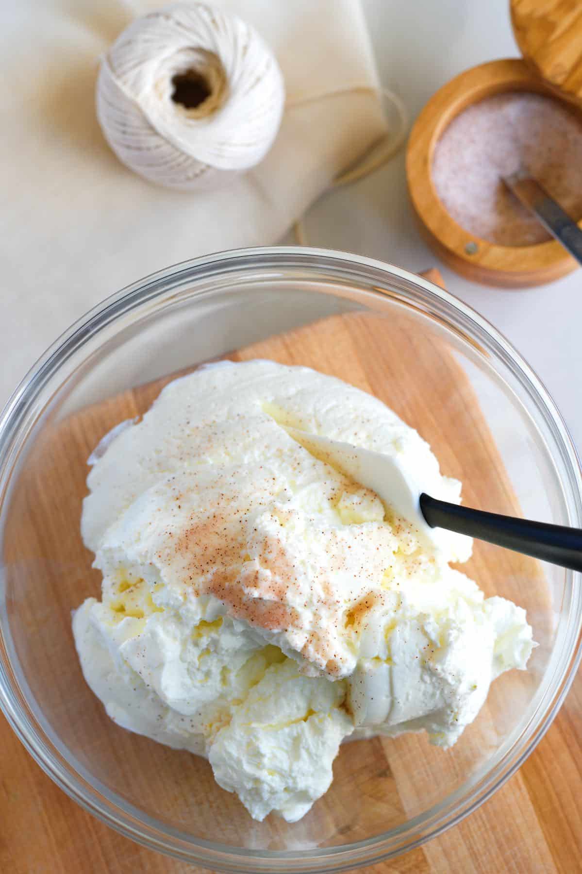 Mixing sea salt into plain yogurt to make labneh.