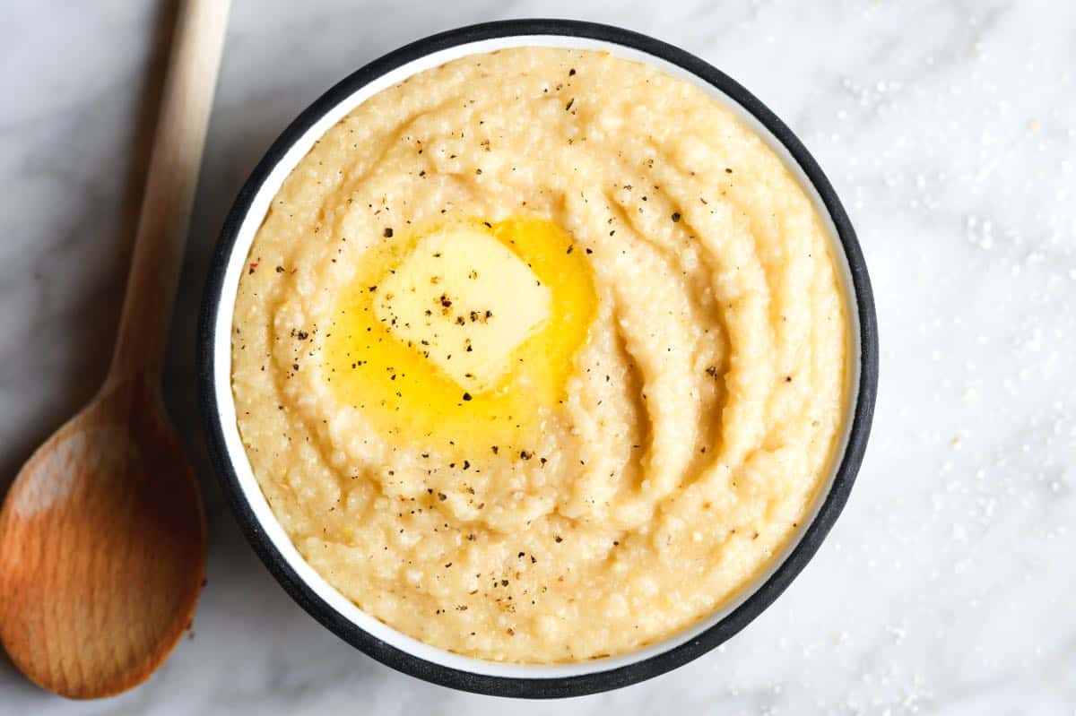 Bowl of grits cooked with stock, butter, and cream.