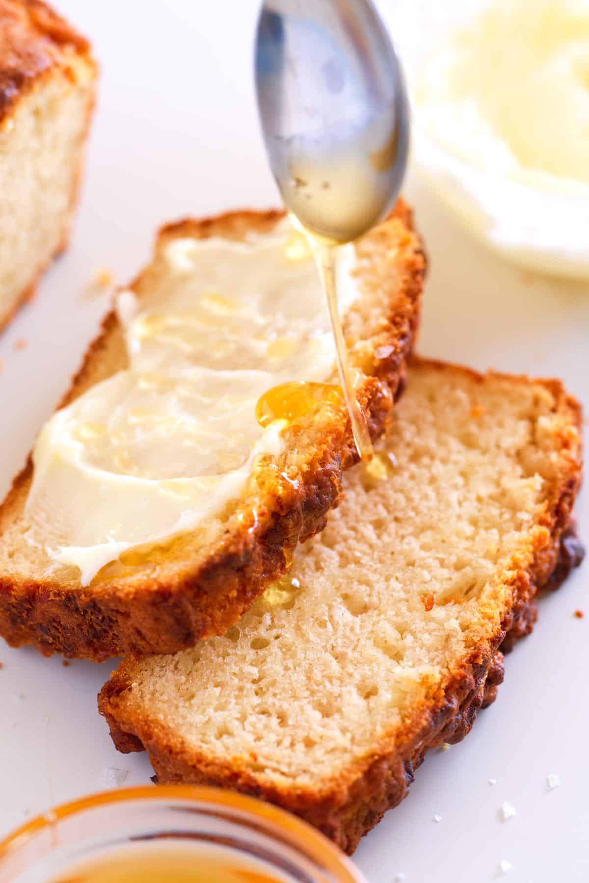 Slices of homemade beer bread with butter and honey