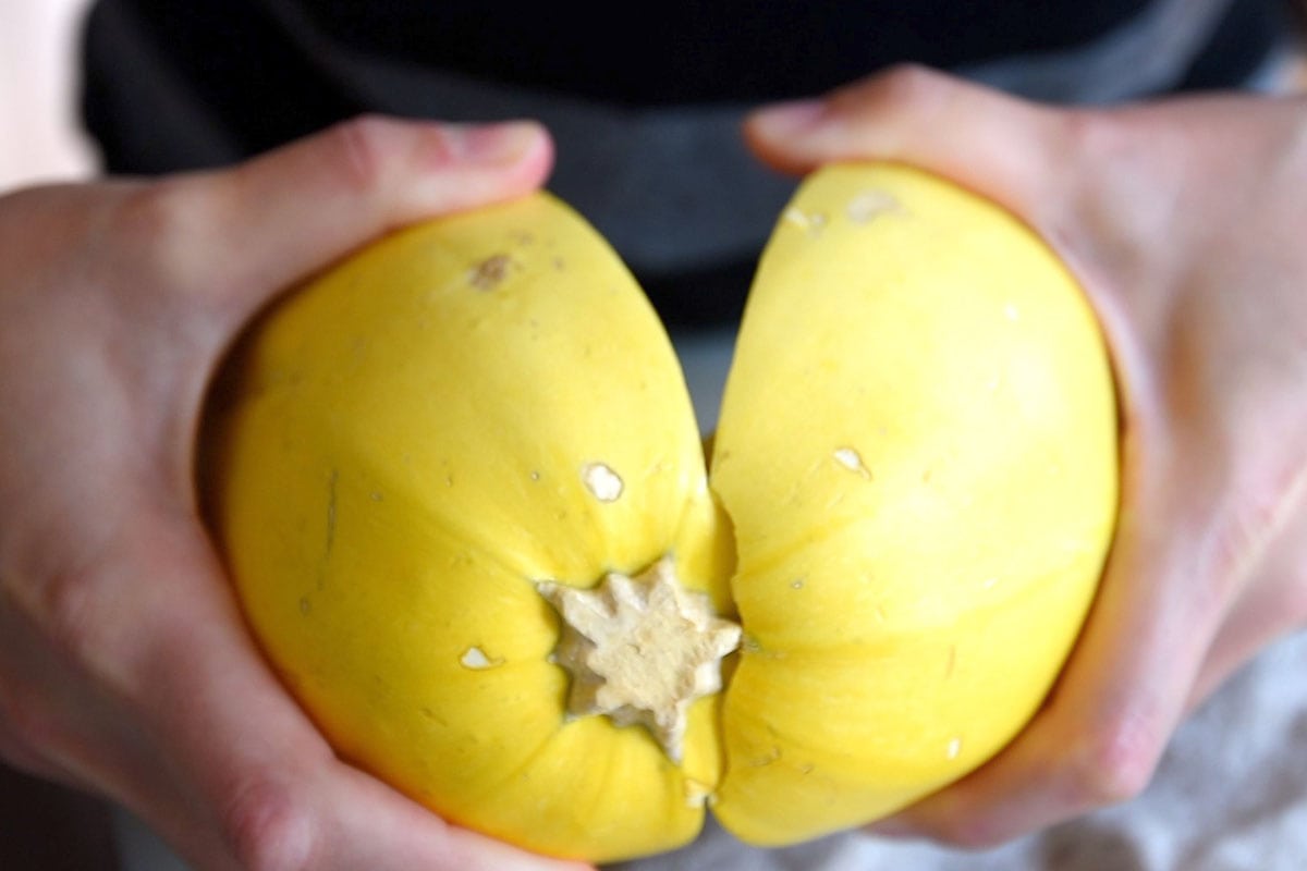 Cutting spaghetti squash in half before cooking in the oven.