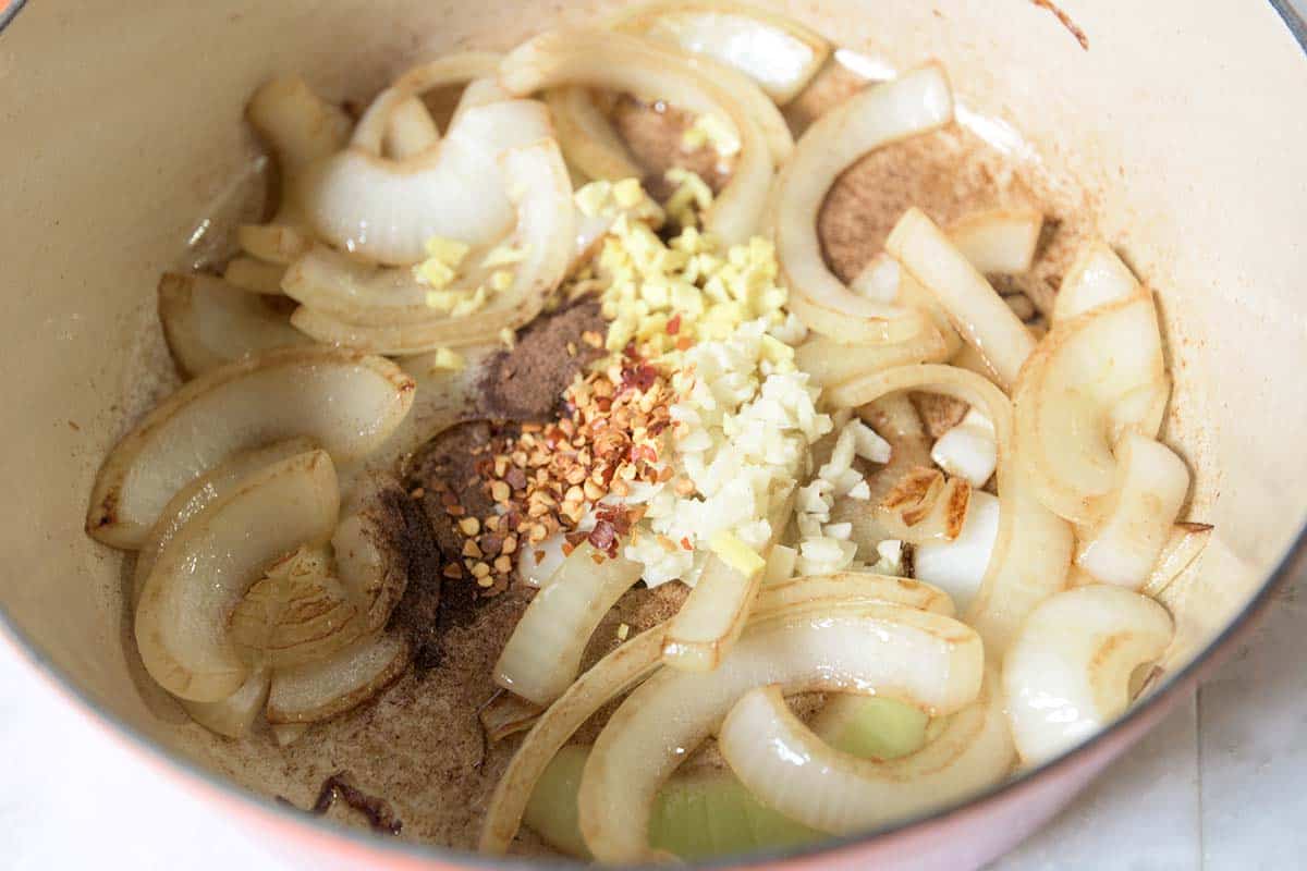 Cooking spices with onion, garlic, and ginger for homemade ketchup.