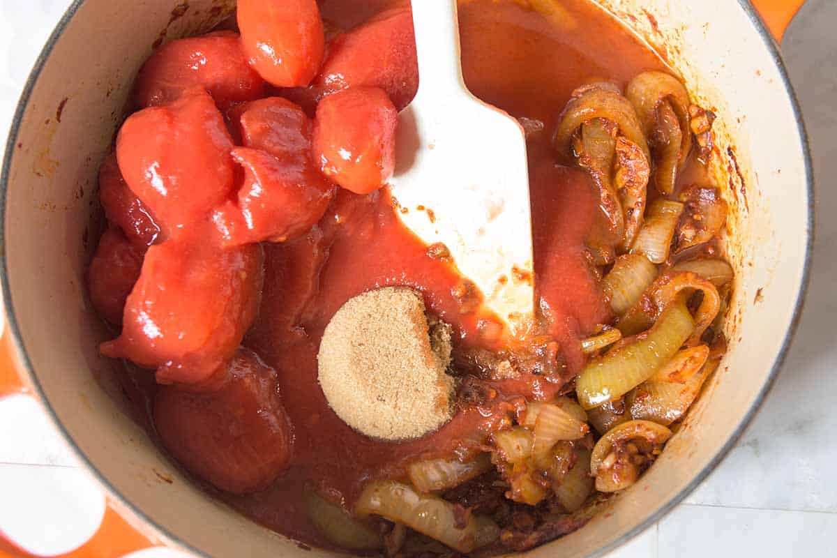 Ketchup ingredients including onions, spices, brown sugar and canned tomatoes.