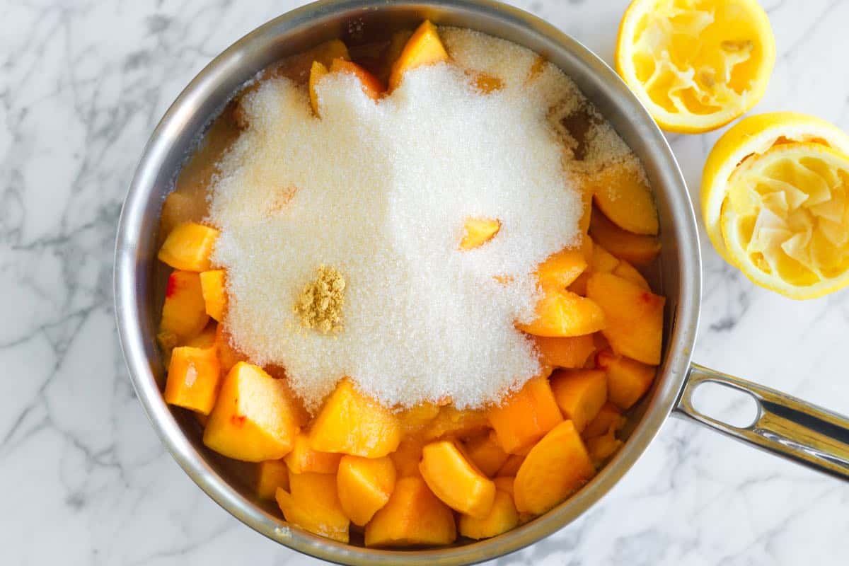 How to Make Peach Jam: Fresh peaches, sugar, lemon juice and ginger in a saucepan.